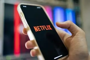 A person opens their Netflix account on their mobile phone. Under new Netflix guidelines, the user cannot share their Netflix password with others.